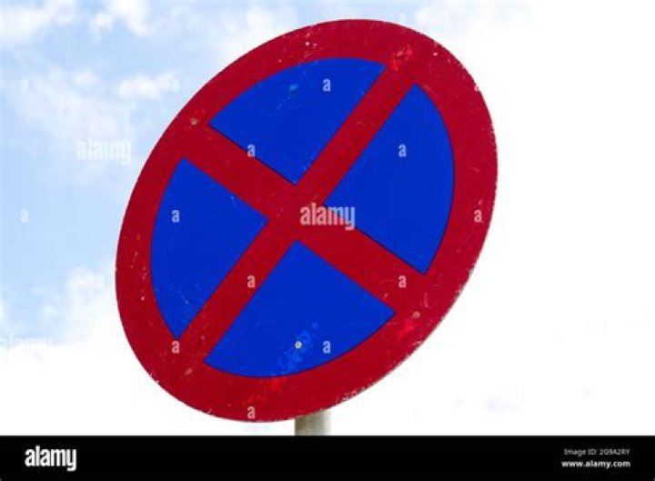 What road sign is a blue circle with a red cross?